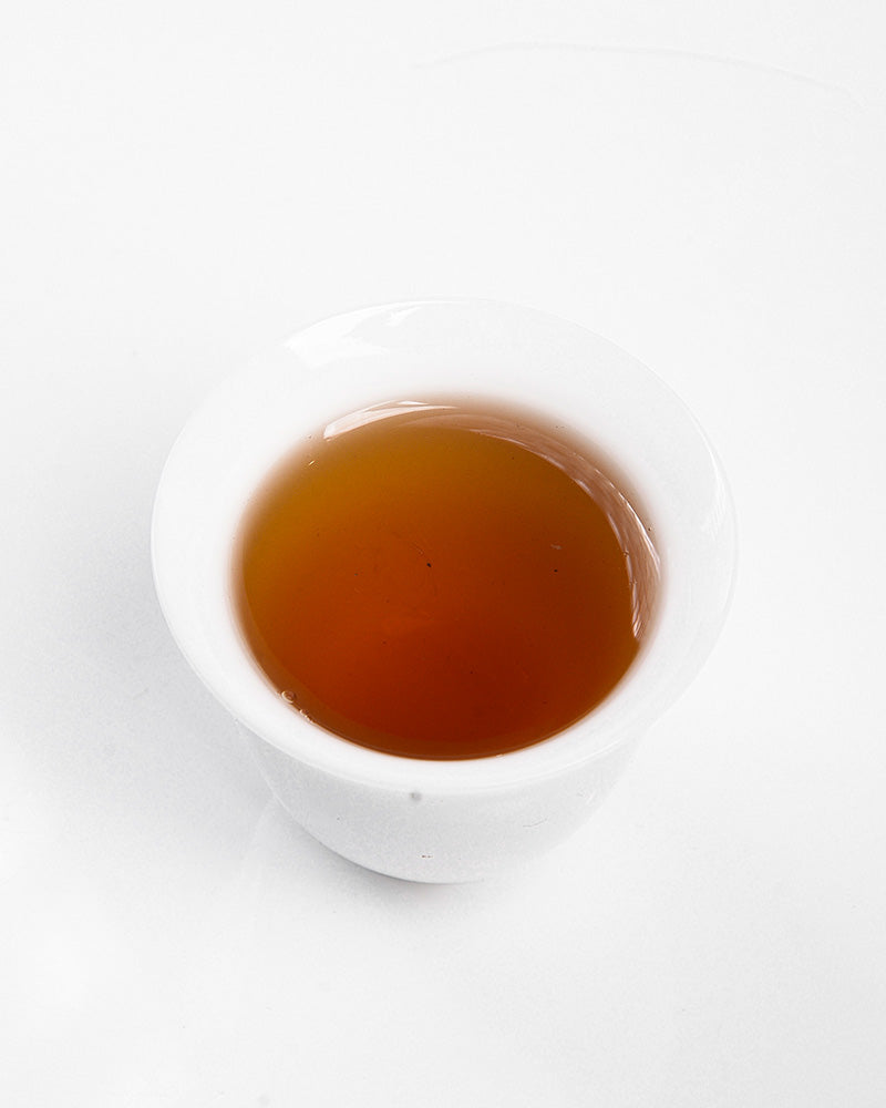A bowl of Zen Tea Master Chinese Black Tea 130g, known for its sweet potato flavor, placed on a white surface.
