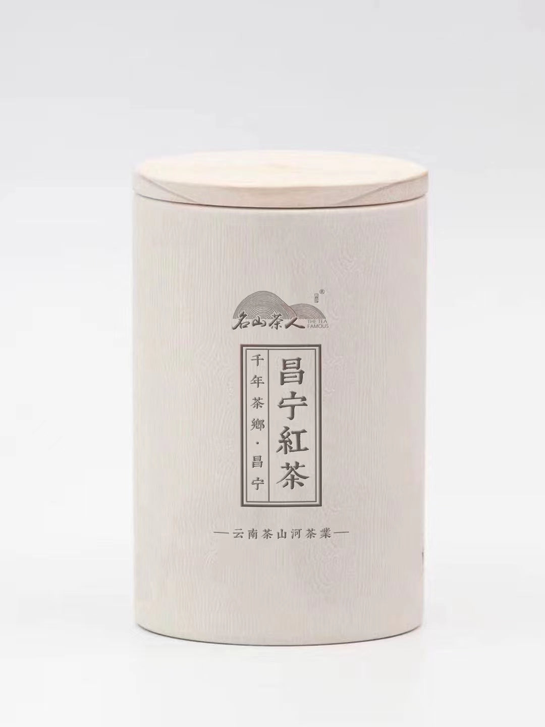 A cylindrical white tea container with Chinese characters on the front and a wooden lid.