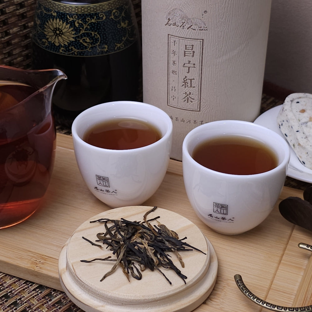 Two cups of pu erh tea on a wooden tray.