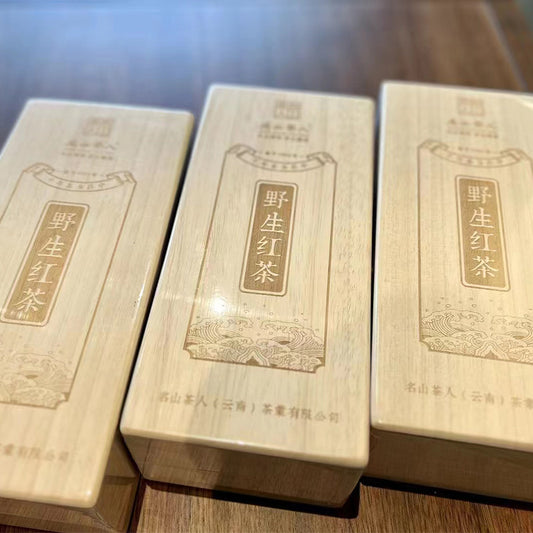 Three wooden boxes containing Chinese writing with Zen Tea Master's Millennium Wild Red Tea 160g.