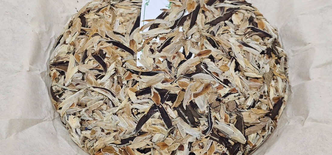 Image 6: A round pile of dried mushroom pieces, reminiscent of the delicate aroma of white tea, rests on a sheet of parchment paper.
